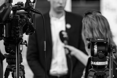 Camera at a media press conference publicity outdoors.