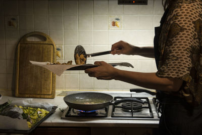 Midsection of woman preparing food in kitchen