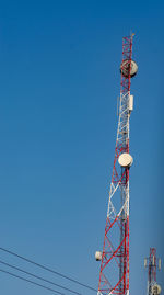 Low angle view of communications tower against clear blue sky