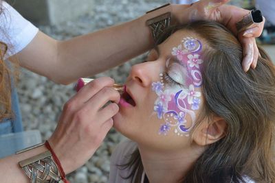 Cropped image of artist applying lipstick to woman