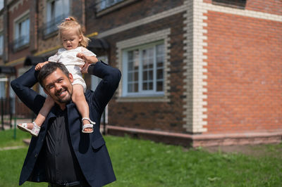 Full length of father and daughter outside house