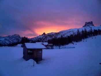 Snow covered field against cloudy sky