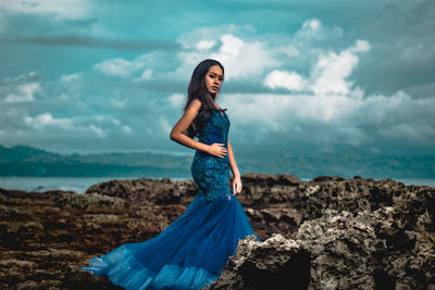 Young woman standing on land against sky