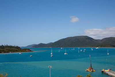 Sailboats in sea against blue sky