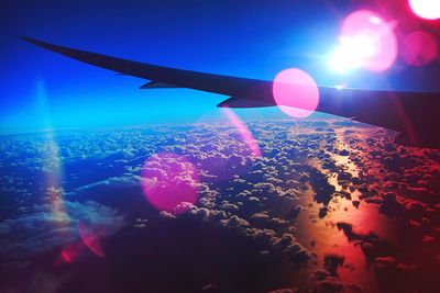 Airplane flying over sea against blue sky