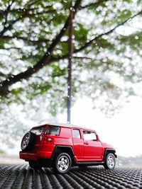 Red toy car against trees