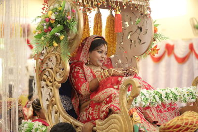 Smiling bride sitting in cart during wedding ceremony