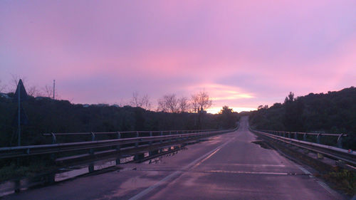 Empty road against sky during sunset