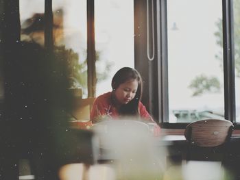 Woman looking through window