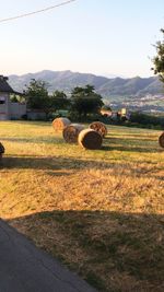 Hay bales on field against sky