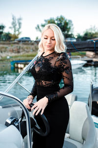 Beautiful young woman in black dress standing in vessel