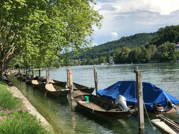 Boats moored in river against sky