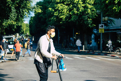 Man with bicycle on road in city