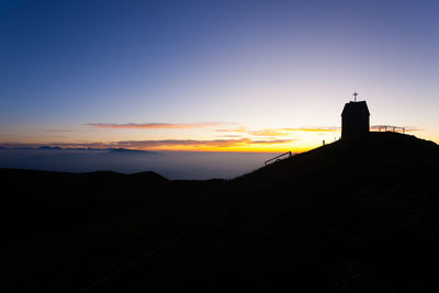 Silhouette of building against sky during sunset