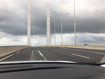 Cars on road against sky seen through car windshield