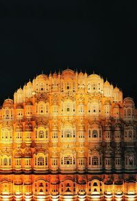 Low angle view of illuminated building against sky at night