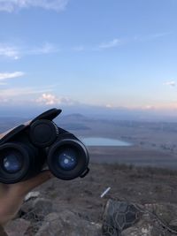 Man photographing camera on land against sky