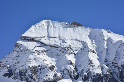 Low angle view of snowcapped mountains against clear blue sky, annapurna