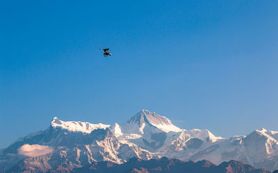 Scenic view of snowcapped mountains against clear blue sky