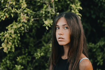 Portrait of beautiful young woman into the wood, look at her deep eyes..