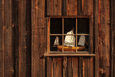 Close-up of window on wooden wall of building