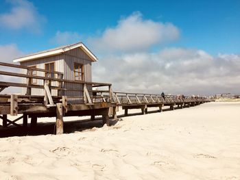 Lifeguard hut on beach against sky