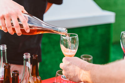 Midsection of man pouring wine in glass