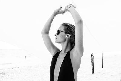 Portrait of woman standing at beach against clear sky