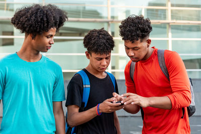 Multiethnic friends using mobile phone in the street