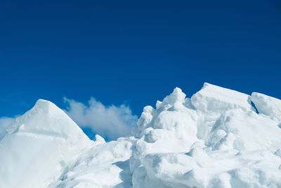 Low angle view of snow against blue sky