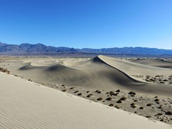 Scenic view of desert against clear blue sky