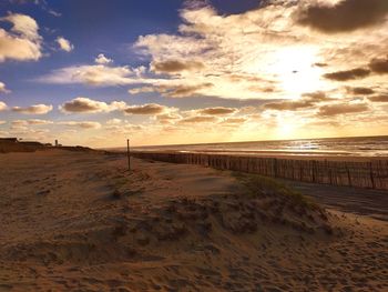 Scenic view of beach against sky during sunset