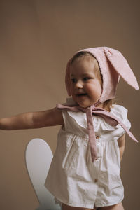 Close-up of cute girl standing against wall