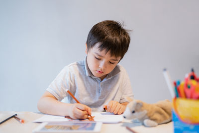 Boy drawing on book at home