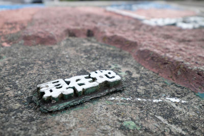 Close-up of text on sand