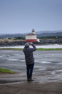 Rear view of man photographing against clear sky