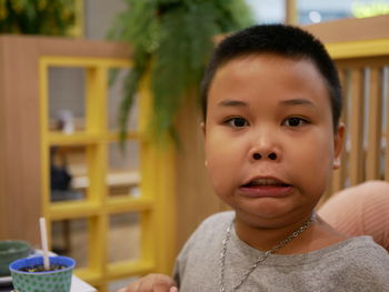 Portrait of boy making face while sitting at home