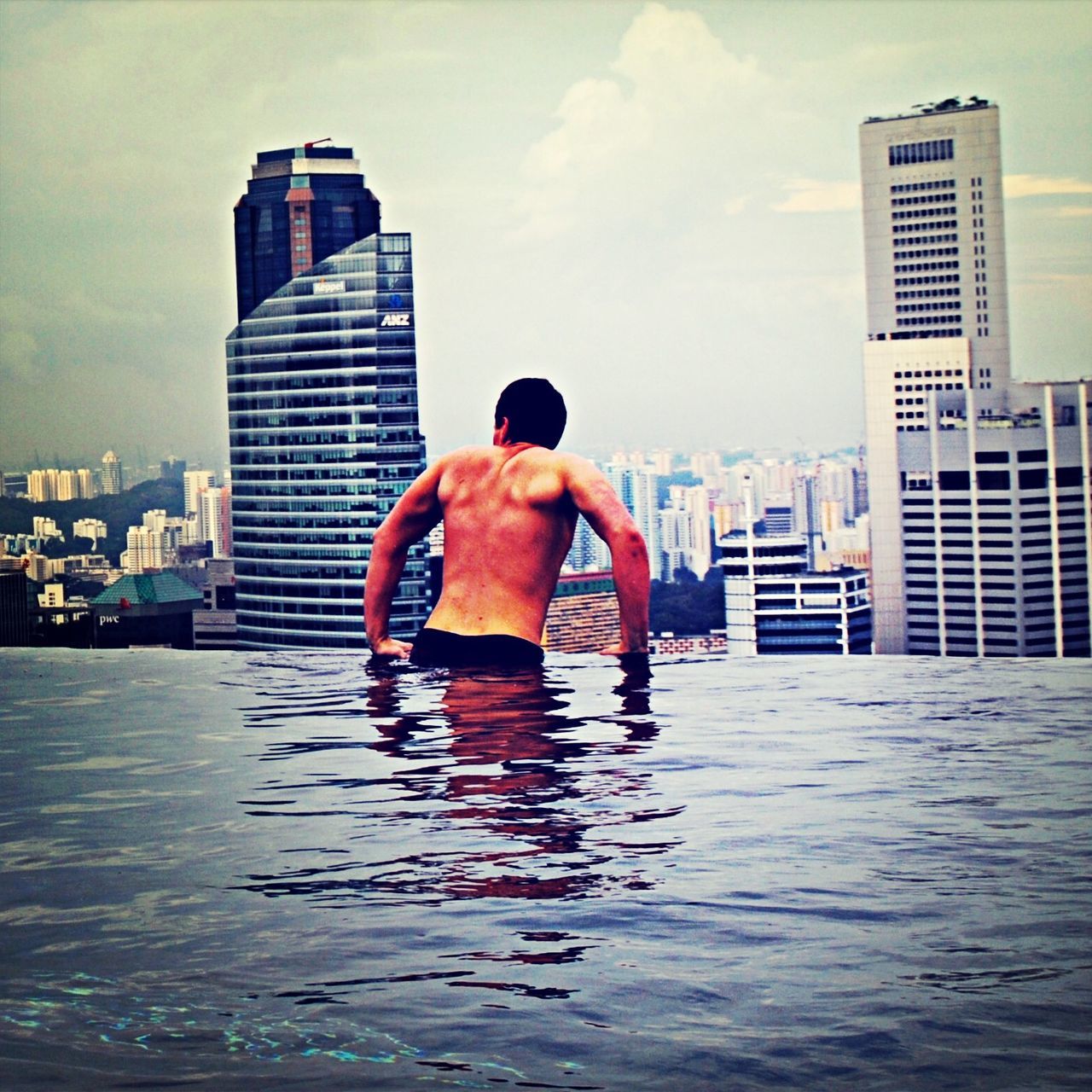 building exterior, built structure, architecture, water, sky, waterfront, city, lifestyles, leisure activity, full length, reflection, cloud - sky, men, modern, cloud, city life, building, skyscraper