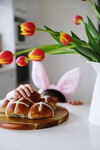 Girl taking sweet bread while hiding under table