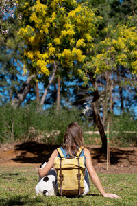 Side view of woman sitting in park