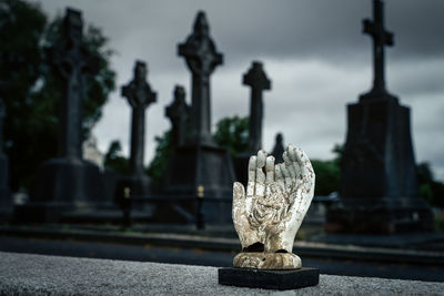 Sculpture of hands holding holly mary and jesus christ, glasnevin cemetery, ireland