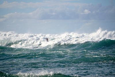 Man surfing in sea against sky