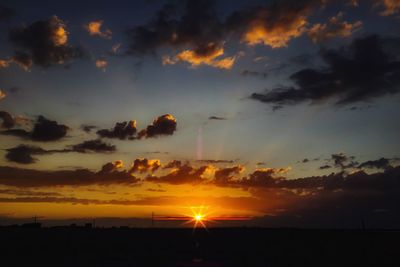 Scenic view of sea against cloudy sky at sunset