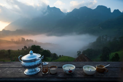 Tea cup on table against mountains