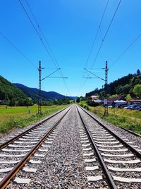 Railroad tracks against clear blue sky