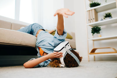 Low section of woman sitting on sofa at home