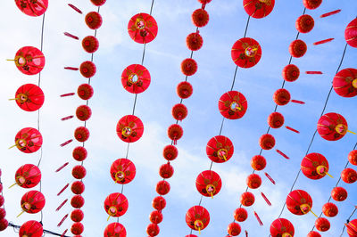 Low angle view of red lanterns hanging against sky