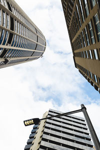 Low angle view of buildings against cloudy sky