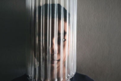 Portrait of woman seen through glass window