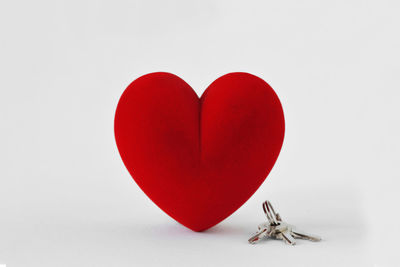 Close-up of red heart shape over white background